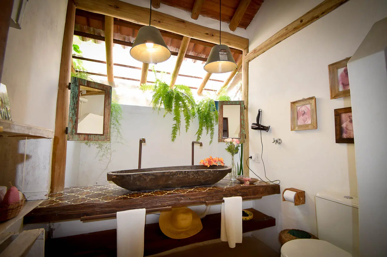 Banheiro da Suíte Baiana com pia de gamela e jardim de inverno