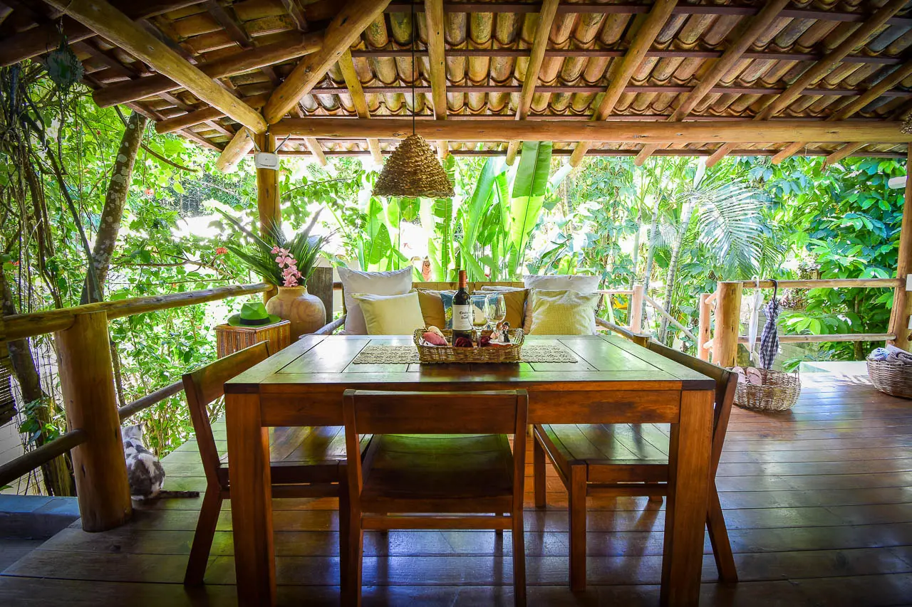 Mesa de jantar na varanda coberta, com vista para o jardim